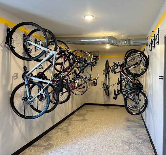 A bike rack with many bikes hanging on it.